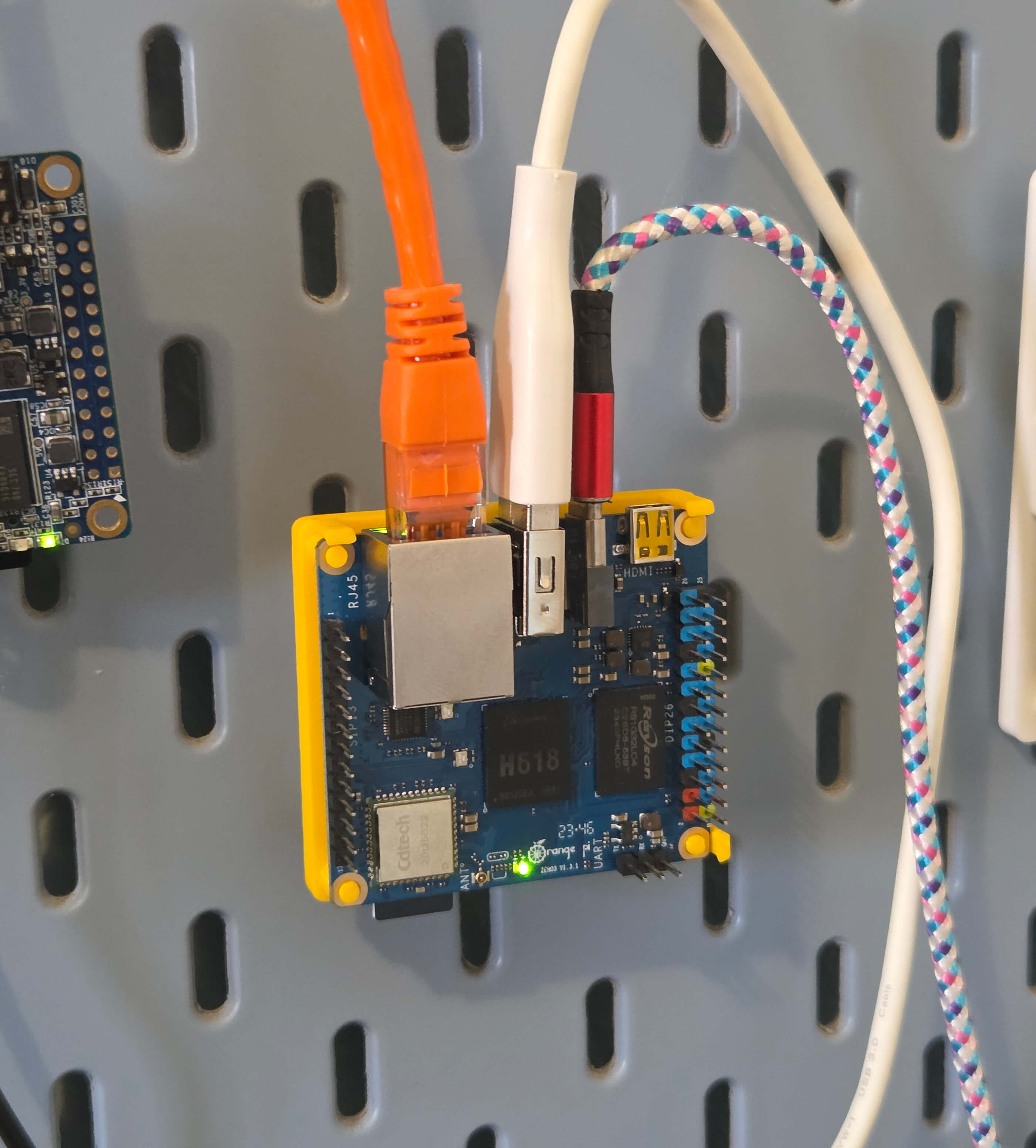 Image of a Orange Pi Zero 3 with an orange ethernet cable connected to it